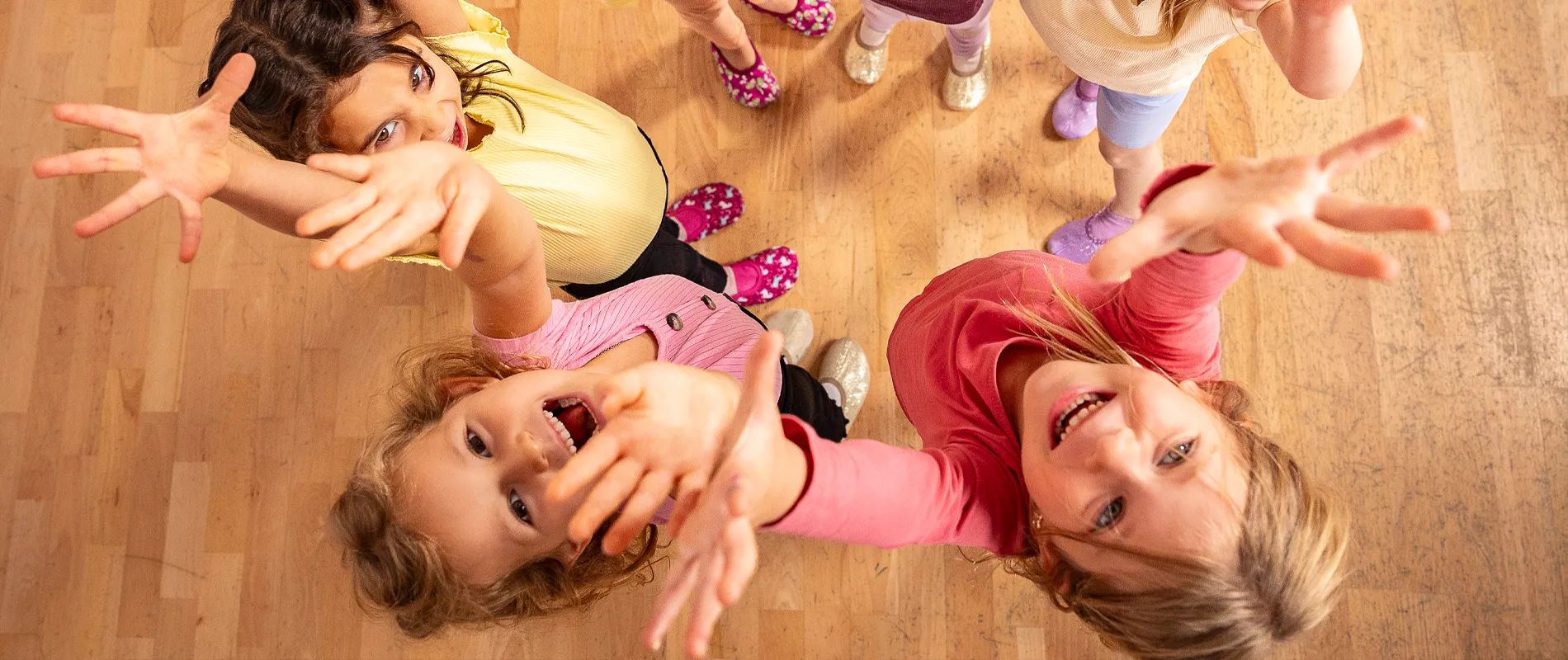 Fröhliche Kinder beim gemeinsamen Tanzen und Bewegen auf dem Parkett – Kinder- und Jugendtanzkurs in der Tanzwelt Regensburg.