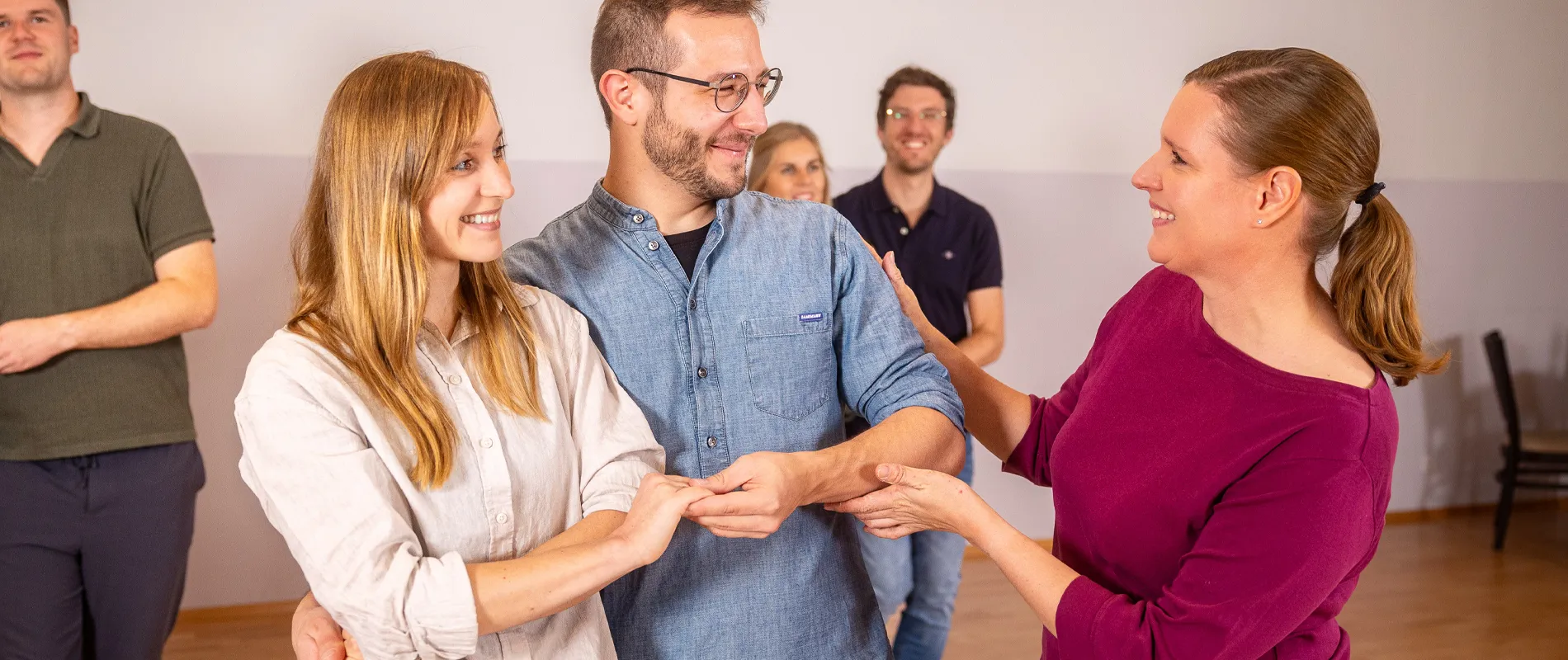 Tanzlehrerin erklärt einem Paar während einer privaten Tanzstunde die richtige Handhaltung – individueller Paartanzunterricht in der Tanzwelt Regensburg.
